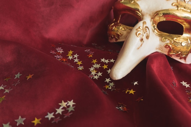 Venetian mask with a long nose and star confetti