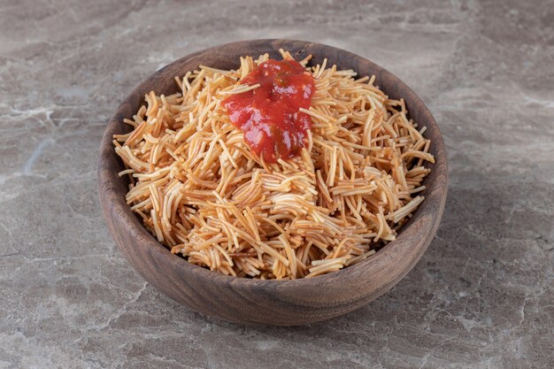 Vermicelli pasta with tomato sauce in the bowl , on the marble.