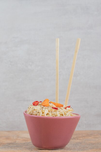 Vermicelli with spices and pepper slices on orange background. High quality photo