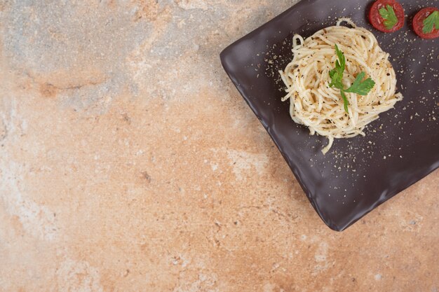 Vermicelli with spices and tomatoes on black plate. High quality illustration