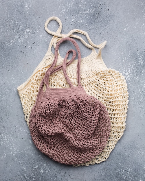 Vertical closeup shot of beige and pink knitted bags