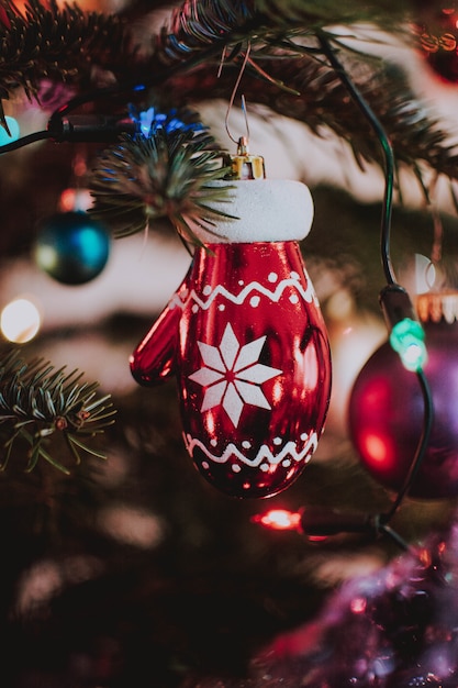 Free photo vertical closeup shot of a christmas glove shaped ornament hanging from the tree