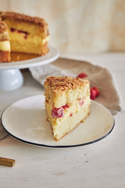 Vertical closeup shot of the delicious Vanilla cream cake with strawberries inside on a white table