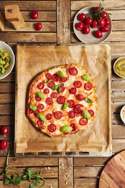 Vertical closeup shot of a pizza with vegetables on wooden table