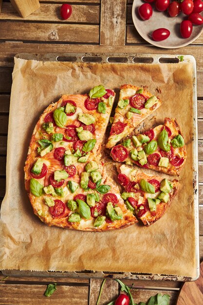 Vertical closeup shot of a pizza with vegetables on wooden table