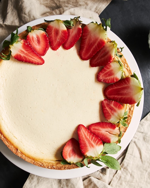 Vertical closeup shot of a Strawberry Cheesecake on a white plate