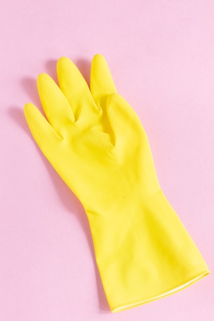 Free Photo vertical closeup shot of a yellow plastic glove on a pink surface