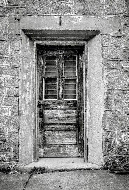 Free Photo vertical grayscale shot of a door at the eastern state penitentiary in philadelphia, pennsylvania