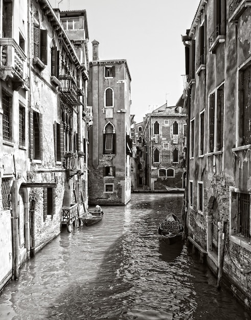 Free Photo vertical greyscale shot of a canal in the historic district of venice, italy