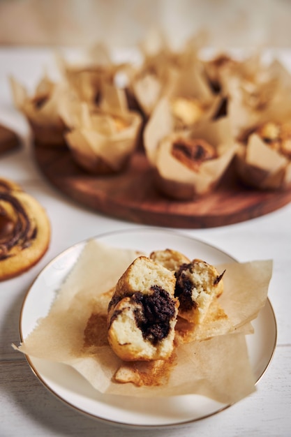 Vertical high angle shot of a delicious chocolate muffin near some muffins and donuts on a table