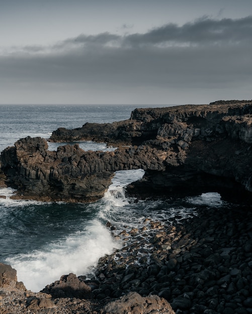 Free Photo vertical high angle shot of the rocky shore of the sea on a gloomy day