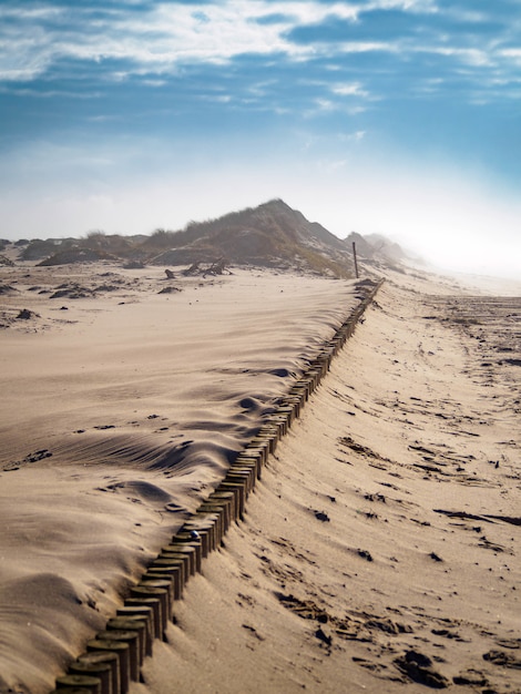 Free photo vertical high angle shot of the sandy ground under the bright cloudy sky