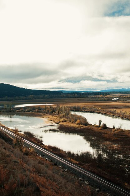 Vertical high angle shot of small ponds in the valley under the cloudy sky