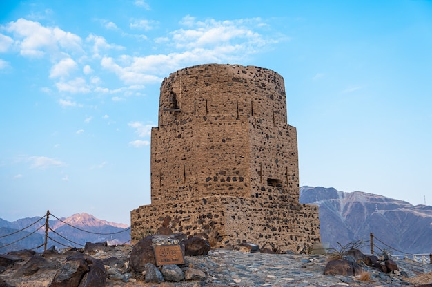 Free photo vertical of the historical al rabi tower against the blue cloudy sky in the united arab emirates