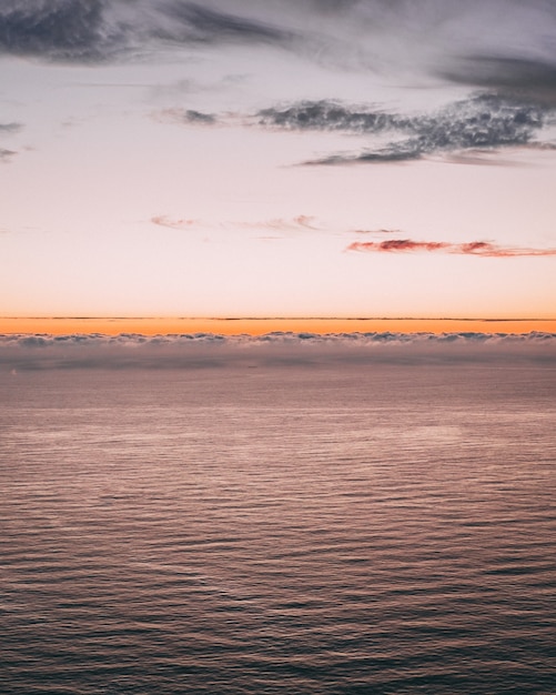 Free Photo vertical image of a beautiful ocean view with waves and an orange horizon