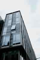 Free photo vertical low angle shot of a beautiful glass building captured during day time