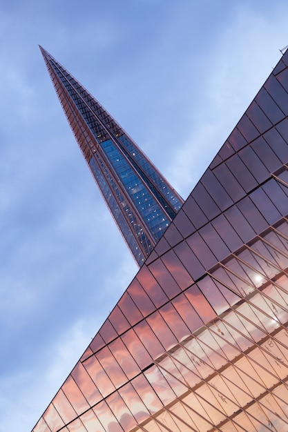 Free photo vertical low angle shot of a laktha center reflecting the sunset in russia