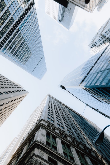 Vertical low angle shot of the skyscrapers under the bright sky in New York City, United States