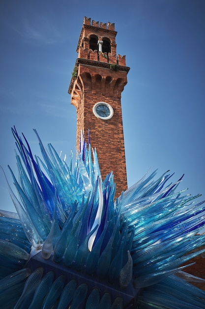 Free Photo vertical low angle shot of a tower and a blue sculpture in murano, italy