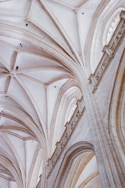 Vertical low angle shot of the white columns and the ceiling of an old building