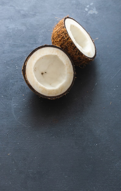 Free Photo vertical overhead closeup shot of cut coconuts on a grey table