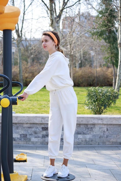 Vertical photo fop young female doing her daily training at the outdoor gym High quality photo