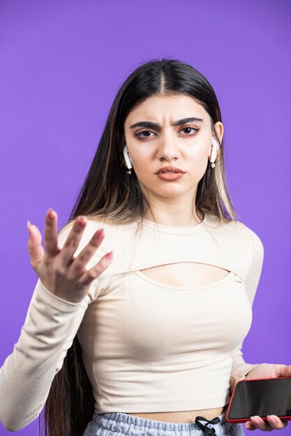 Vertical photo of young girl looking camera with anger Young beautiful girl on purple background