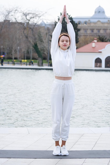 Vertical photo of young lady raised her hands and doing her exercises High quality photo