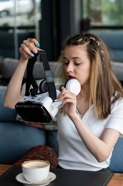 Vertical photo of young lady wearing VR set at the reatauranat