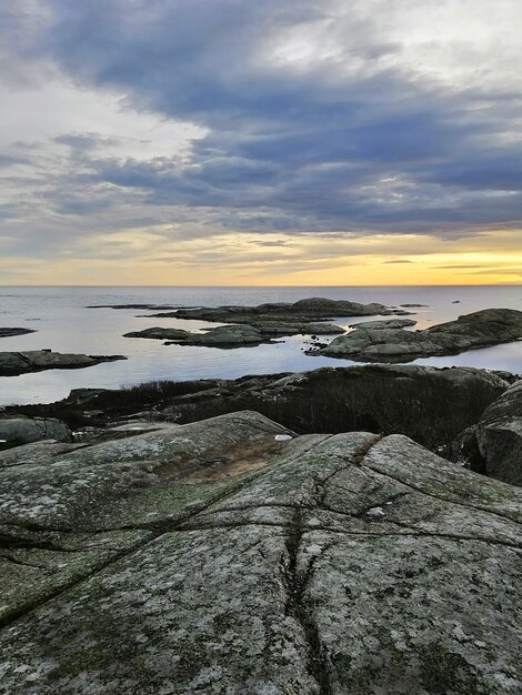 Vertical picture of rocks surrounded by the sea during the sunset in Rakke in Norway