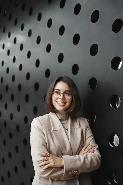 Free photo vertical portrait of successful goodlooking young professional headhunter female entrepreneur or office worker in beige blazer look away cross hands chest confident manage own business