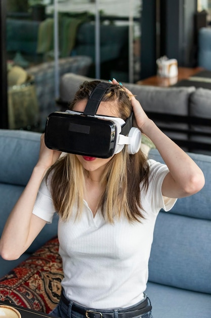 Free photo vertical portrait of young lady wearing vr set and sitting at the restaurant