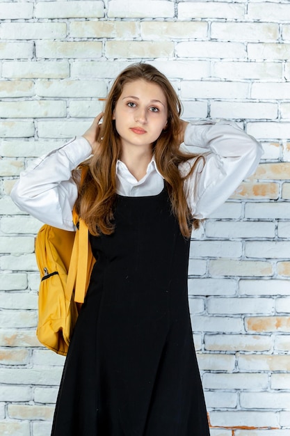 Vertical portrait of young schoolgirl looking at the camera