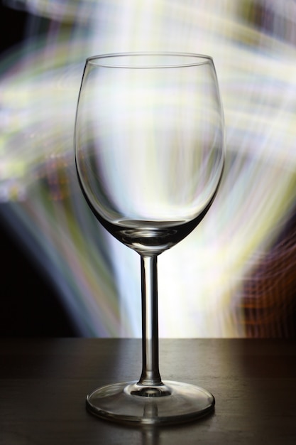 Free photo vertical selective focus shot of an empty wine glass with blurry lights