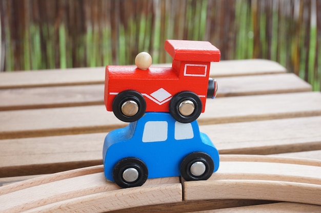 Free Photo vertical selective focus shot of a red wagon and a blue car placed on each other on a wooden table