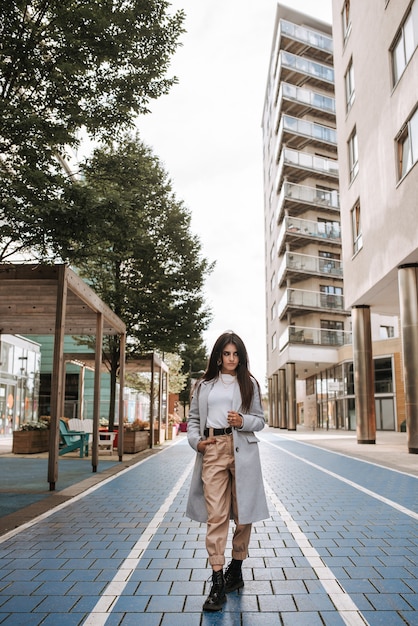 Vertical shot of an Asian young woman posing in the street