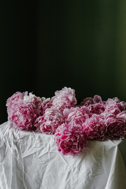 Free Photo vertical shot of beautiful blooming pastel pink peonies on a table