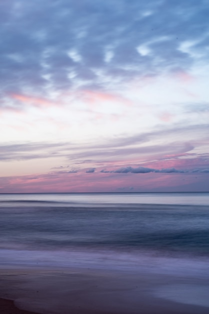 Vertical shot of the beautiful colorful sky over the sea during sunrise