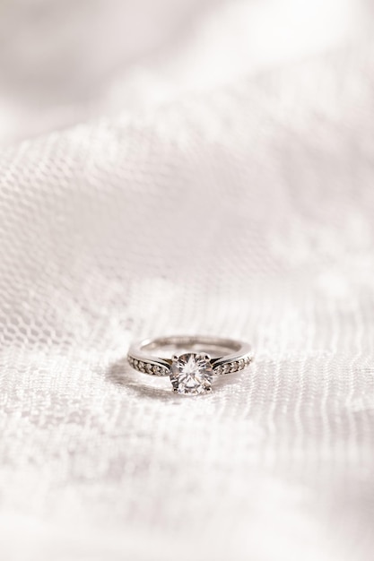 Free photo vertical shot of a beautiful diamond ring on a white surface