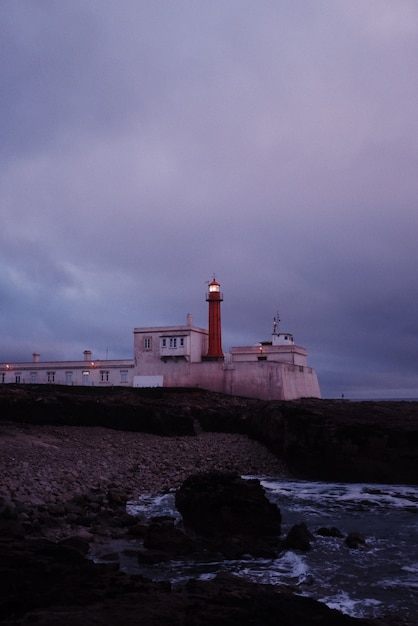 Vertical shot of a beautiful scenery of Lighthouse after sunset with purple sky