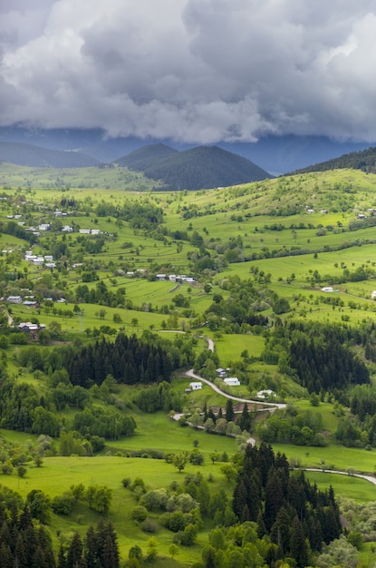 Vertical shot of a beautiful village on the grass covered hills