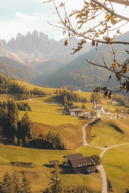 Free Photo vertical shot of a beautiful village on a hill surrounded by mountains during daylight