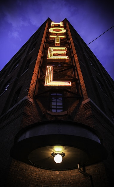 Free Photo vertical shot of a big building with a hotel sign and a dark blue sky