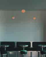 Free photo vertical shot of black stools beside pedestal tables and benches inside a cafe