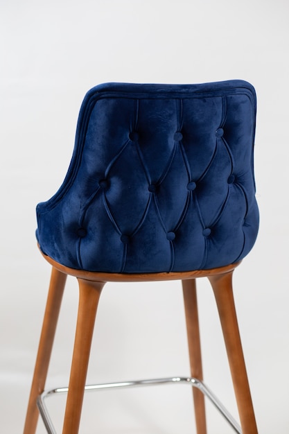 Free photo vertical shot of a blue chair with buttons behind a white background