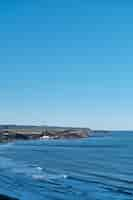 Free photo vertical shot of a blue sea and a clear sky during daytime