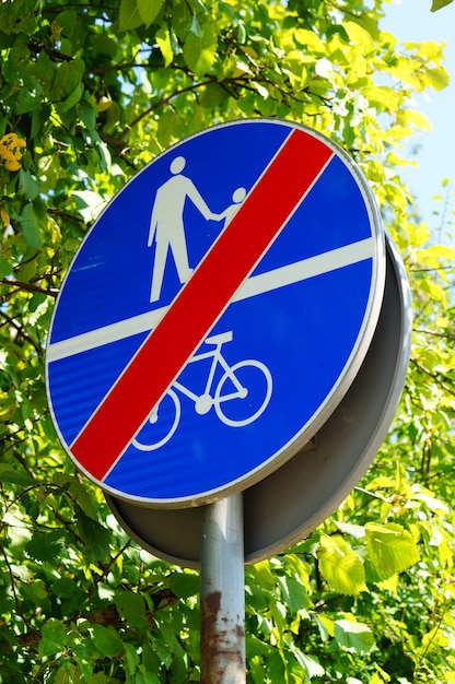 Vertical shot of a blue sign prohibiting the access of people and bicycles