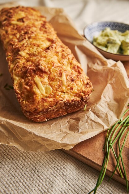 Vertical shot of bread with cheese herbal butter on a wood