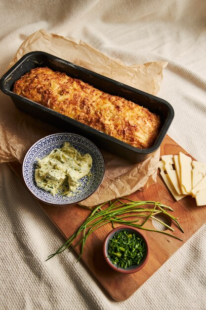 Vertical shot of bread with cheese herbal butter on a wood