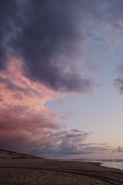 Free photo vertical shot of a breathtaking purple sky at the beach after sunset